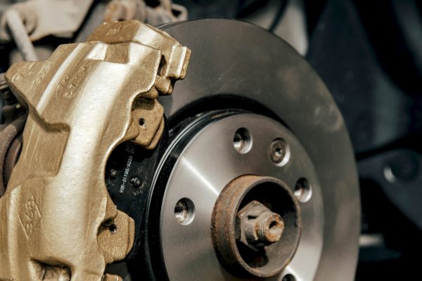 Close-up image of gold painted brake caliper on brake disc.